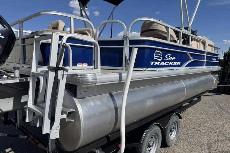 Slide: The Image of 2017 Sun Tracker FISHIN' BARGE® 20 DLX pontoon boat on trailer, blue and silver design. - 56