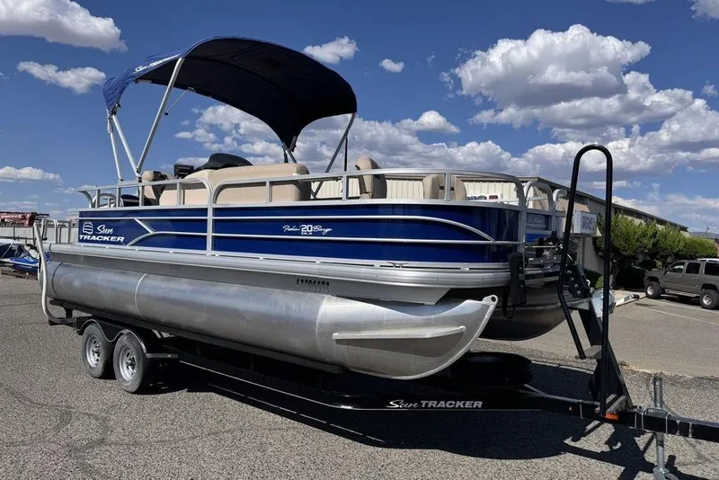 Slide: The Image of 2017 Sun Tracker FISHIN' BARGE® 20 DLX pontoon boat on trailer under blue sky. - 57
