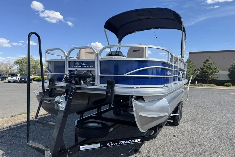 Slide: The Image of 2017 Sun Tracker FISHIN' BARGE® 20 DLX pontoon boat on trailer, parked outdoors. - 6