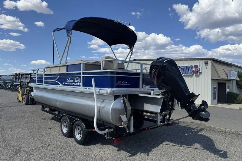 Slide: The Image of 2017 Sun Tracker FISHIN' BARGE® 20 DLX pontoon boat on trailer, outdoor setting. - 8