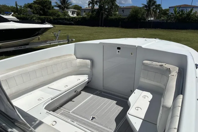 Slide: The Image of 2000 Intrepid 322 Cuddy boat interior with white seating and storage compartments. - 11