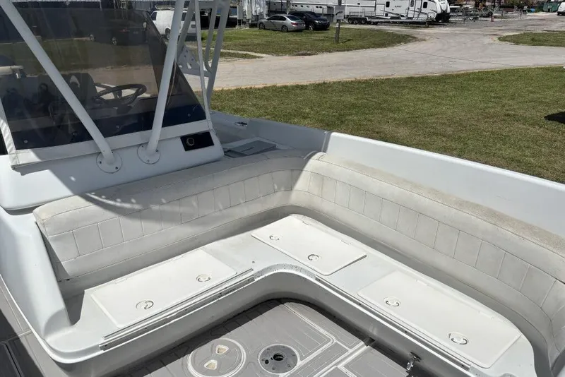 Slide: The Image of 2000 Intrepid 322 Cuddy boat interior with white seating and helm area. - 12