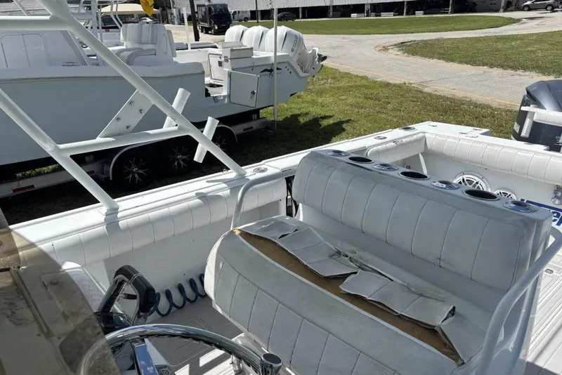 Slide: The Image of Interior view of a 2000 Intrepid 322 Cuddy boat with white seating and cup holders. - 13