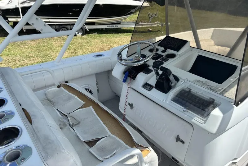Slide: The Image of 2000 Intrepid 322 Cuddy boat cockpit with steering wheel and control panel. - 14