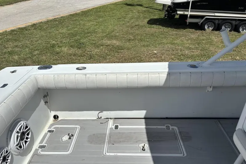 Slide: The Image of 2000 Intrepid 322 Cuddy boat interior with cushioned seating and deck details. - 19