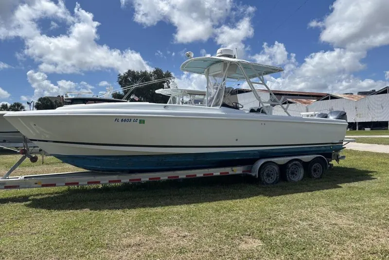Slide: The Image of 2000 Intrepid 322 Cuddy boat on trailer under blue sky. - 3