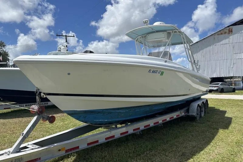 Slide: The Image of 2000 Intrepid 322 Cuddy boat on trailer under blue sky. - 4