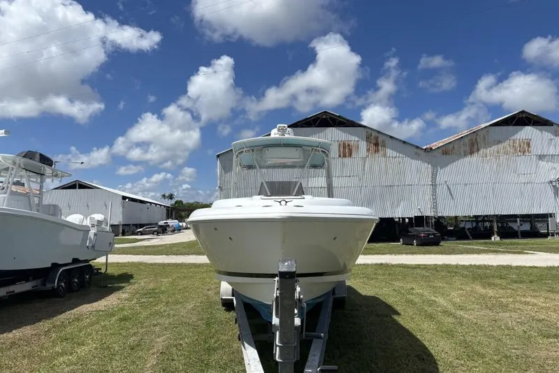 Slide: The Image of 2000 Intrepid 322 Cuddy boat on trailer, parked outdoors under a blue sky. - 7