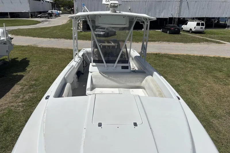 Slide: The Image of 2000 Intrepid 322 Cuddy boat on grass, showcasing spacious deck and seating area. - 8