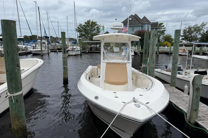 Slide: The Image of 2015 Cobia 256 Center Console boat docked at marina with overcast sky. - 16