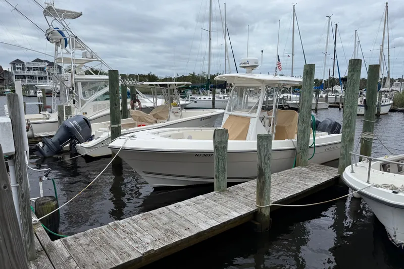 Slide: The Image of 2015 Cobia 256 Center Console boat docked at marina with overcast sky. - 17