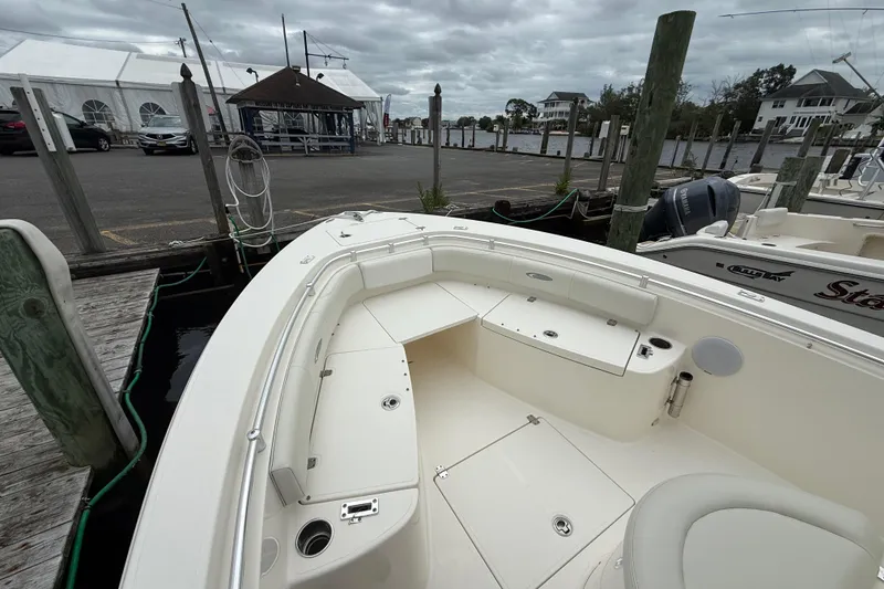 Slide: The Image of 2015 Cobia 256 Center Console boat docked at marina under cloudy skies. - 18