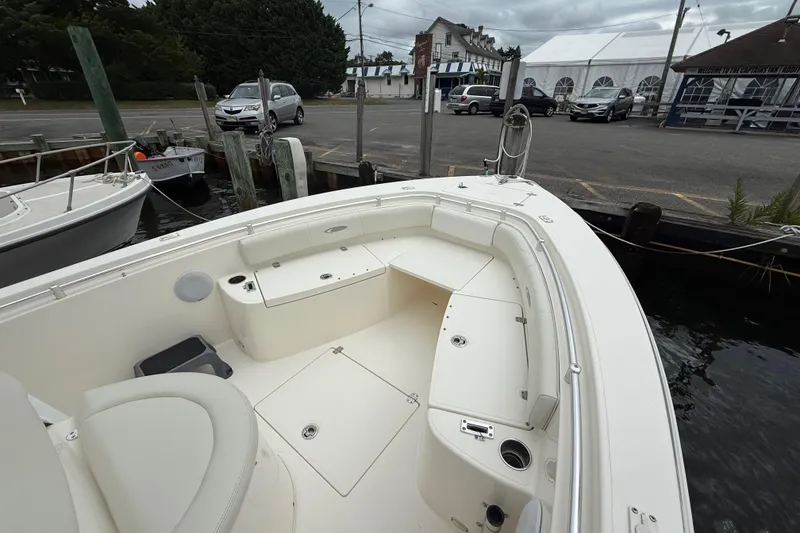 Slide: The Image of 2015 Cobia 256 Center Console boat docked at marina with overcast sky. - 19