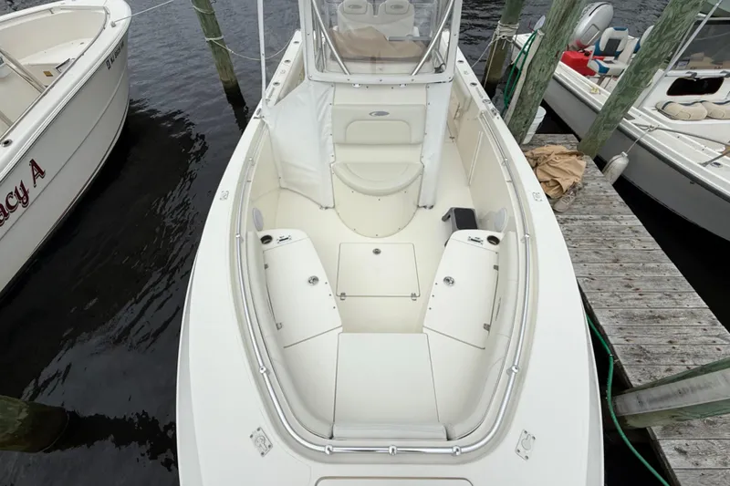 Slide: The Image of 2015 Cobia 256 Center Console boat docked, showcasing spacious seating and storage. - 20