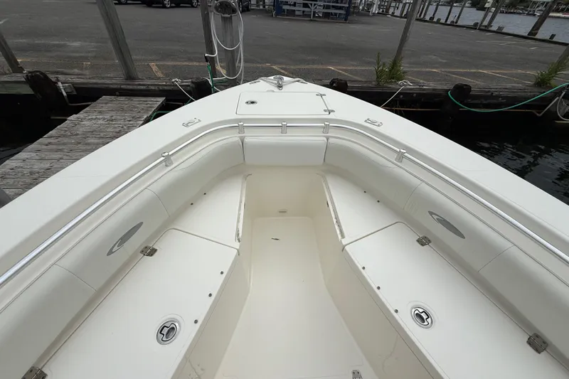 Slide: The Image of 2015 Cobia 256 Center Console boat interior at dock, featuring spacious seating and storage. - 23