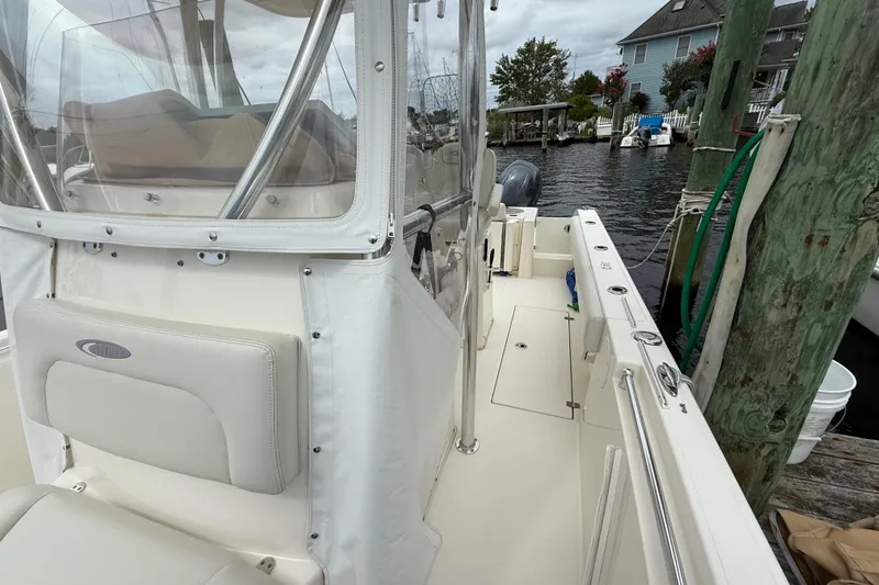Slide: The Image of 2015 Cobia 256 Center Console boat docked, featuring spacious deck and seating area. - 26