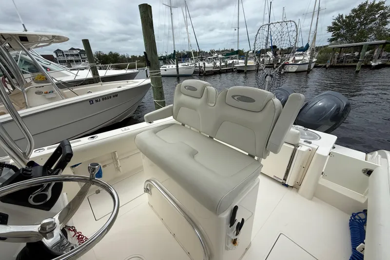 Slide: The Image of 2015 Cobia 256 Center Console boat docked at marina with dual engines. - 27