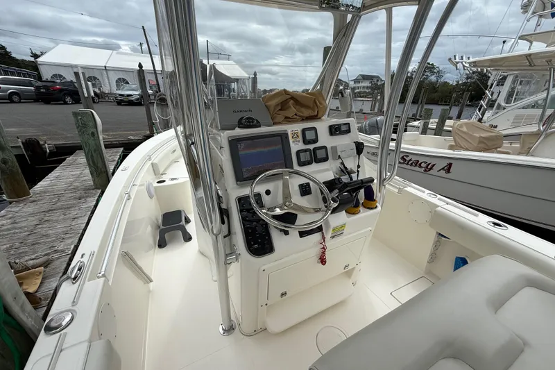 Slide: The Image of 2015 Cobia 256 Center Console boat interior with steering wheel and navigation equipment. - 28
