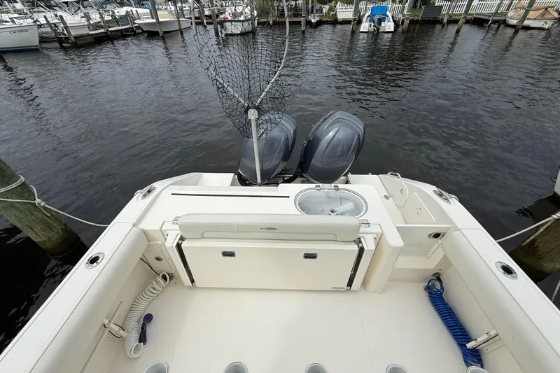 Slide: The Image of 2015 Cobia 256 Center Console boat with dual engines docked at marina. - 32