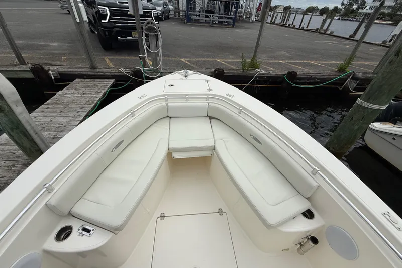 Slide: The Image of 2015 Cobia 256 Center Console boat with white seating at dockside. - 35