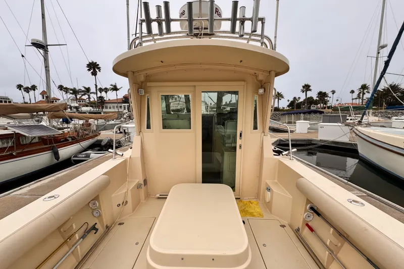 Slide: The Image of 2003 Albin 28 TE boat docked at marina, showcasing spacious deck and cabin entrance. - 10