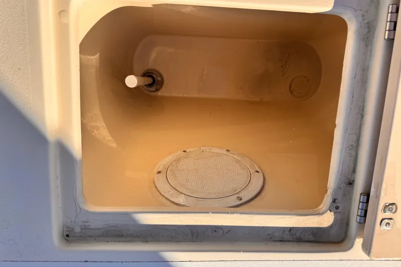 Slide: The Image of Storage compartment in a 2003 Albin 28 TE boat, featuring a circular vent. - 12