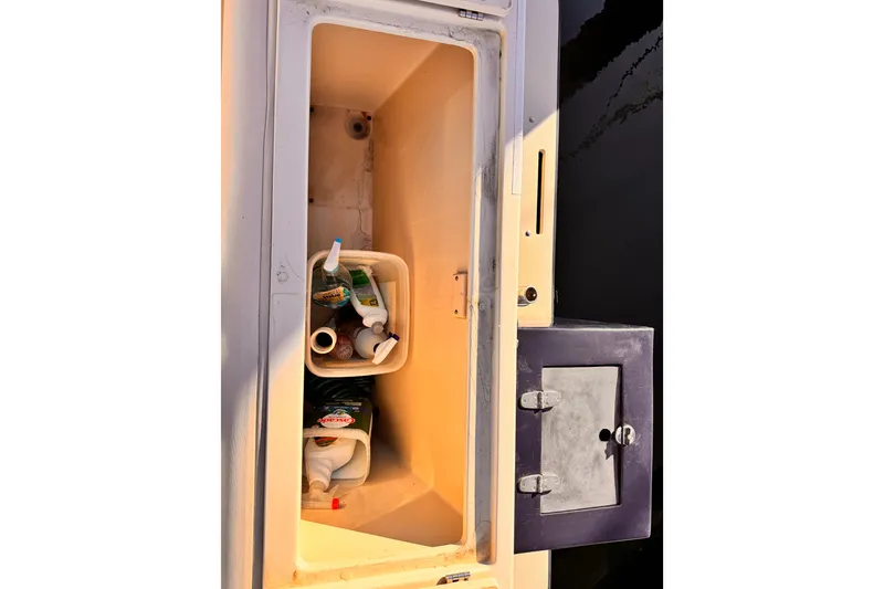 Slide: The Image of Storage compartment on a 2003 Albin 28 TE boat with cleaning supplies. - 13
