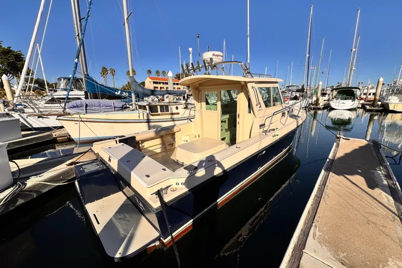 Slide: The Image of 2003 Albin 28 TE boat docked in a marina under clear blue skies. - 2