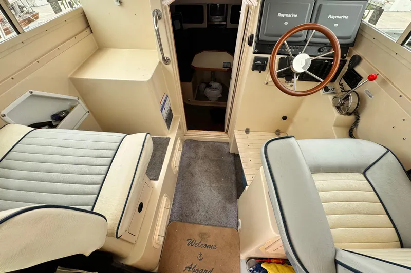 Slide: The Image of Interior of 2003 Albin 28 TE boat with steering wheel and seating. - 21