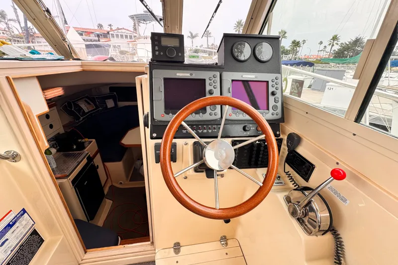 Slide: The Image of 2003 Albin 28 TE boat cockpit with steering wheel and navigation equipment. - 23