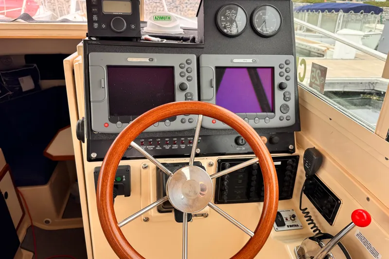 Slide: The Image of 2003 Albin 28 TE boat helm with wooden steering wheel and navigation instruments. - 24