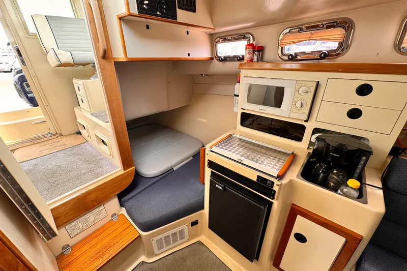 Slide: The Image of 2003 Albin 28 TE cabin interior with kitchenette, microwave, and seating area. - 30