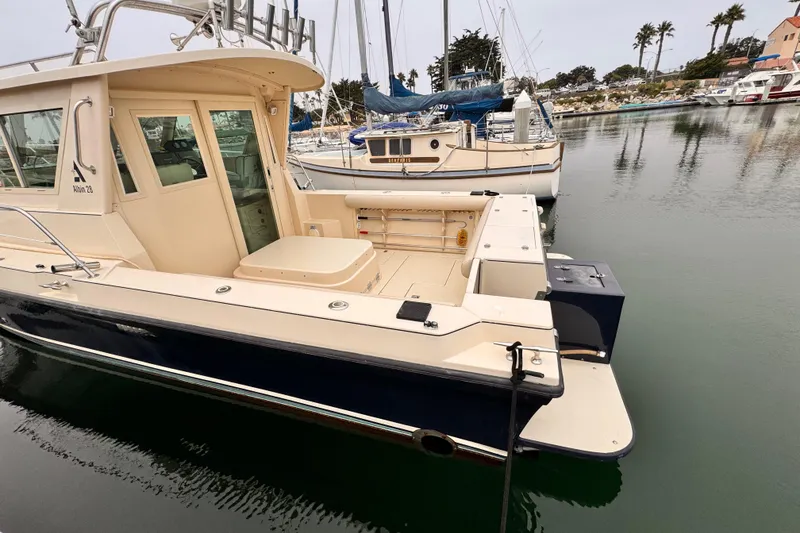 Slide: The Image of 2003 Albin 28 TE boat docked in a marina, showcasing its spacious deck and cabin. - 37