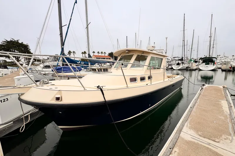 Slide: The Image of 2003 Albin 28 TE boat docked in a marina, surrounded by sailboats. - 38