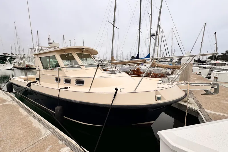Slide: The Image of 2003 Albin 28 TE boat docked at a marina with sailboats in the background. - 39