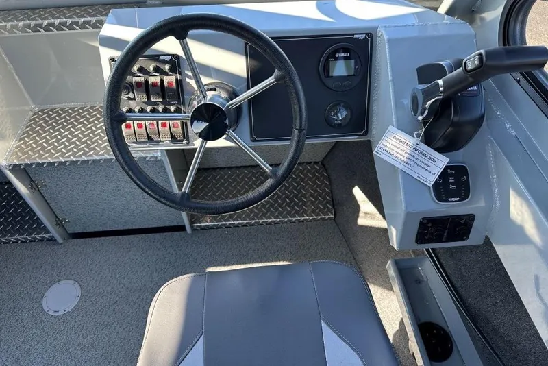 Slide: The Image of Steering console of 2025 Hewescraft 240 Ocean Pro ET HT boat, featuring control panel and switches. - 6
