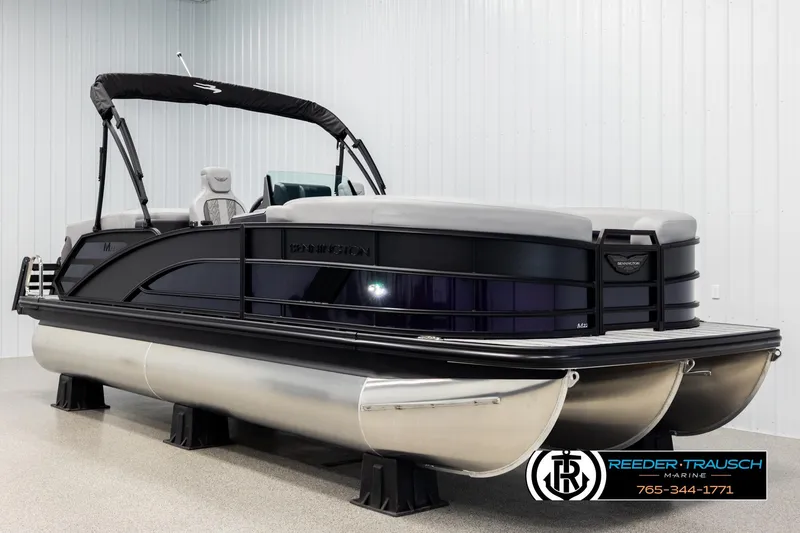 Slide: The Image of 2026 Bennington 22 MFBSE pontoon boat in showroom, sleek design, black and silver finish. - 2