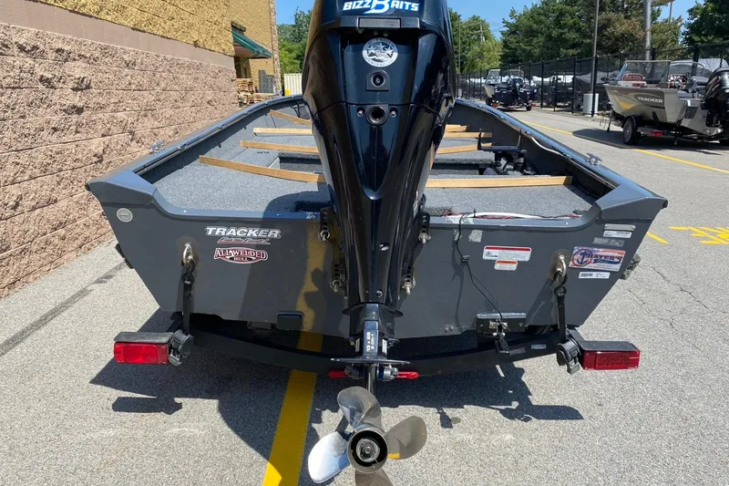 Slide: The Image of 2017 Tracker Guide V-16 Laker DLX T boat with outboard motor, parked outdoors. - 2