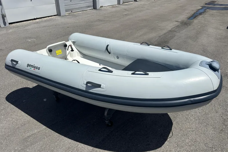 Slide: The Image of 2025 Geniuss 285 TILLER inflatable boat on pavement, showcasing sleek design and durability. - 11