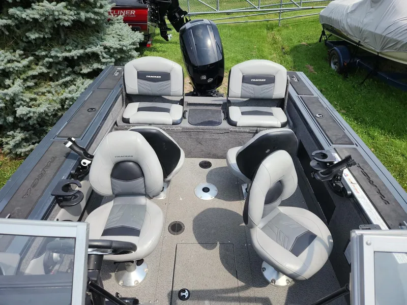 Slide: The Image of 2019 Tracker Targa V-18 Combo boat interior with four gray seats and fishing rod holders. - 7