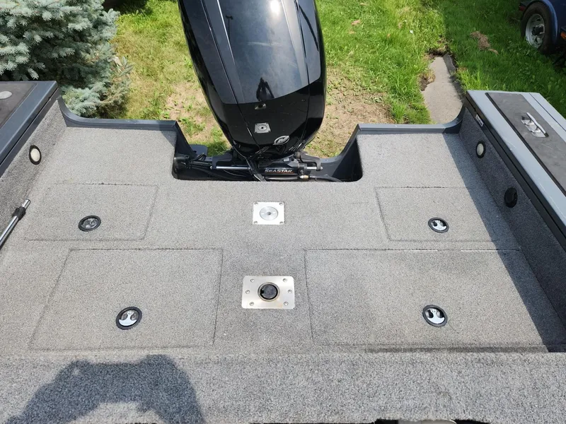 Slide: The Image of 2019 Tracker Targa V-18 Combo boat deck with motor, on grassy background. - 8