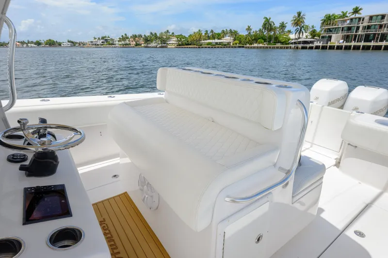 Slide: The Image of 2018 SeaHunter 33 Tournament boat interior with white seating and steering wheel, dockside view. - 6