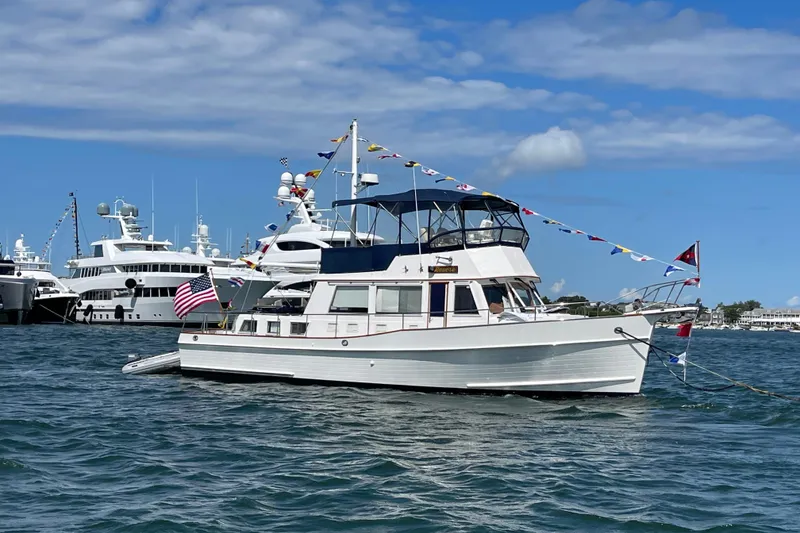 Slide: The Image of 2002 Grand Banks 42 Classic yacht adorned with flags, docked in a marina. - 1