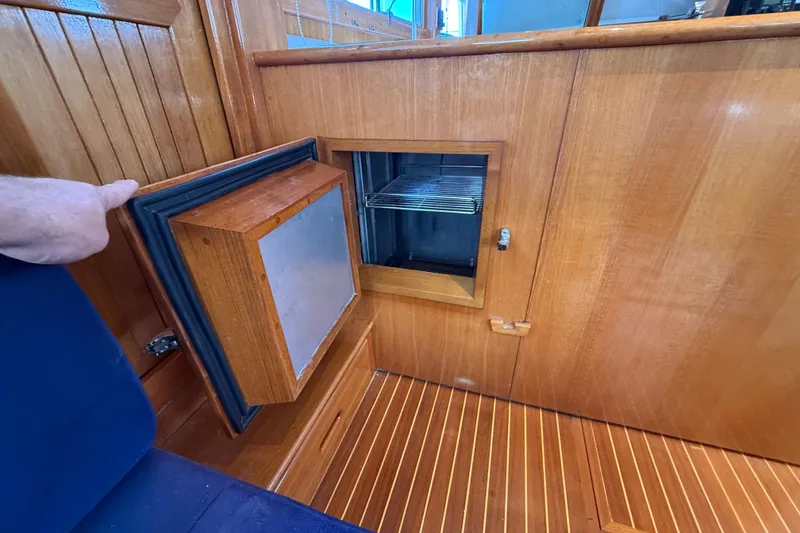 Slide: The Image of Wooden interior of 2002 Grand Banks 42 Classic yacht with open storage compartment. - 11
