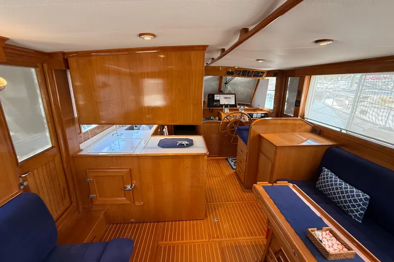 Slide: The Image of Interior of 2002 Grand Banks 42 Classic yacht with wooden finish and blue seating. - 13