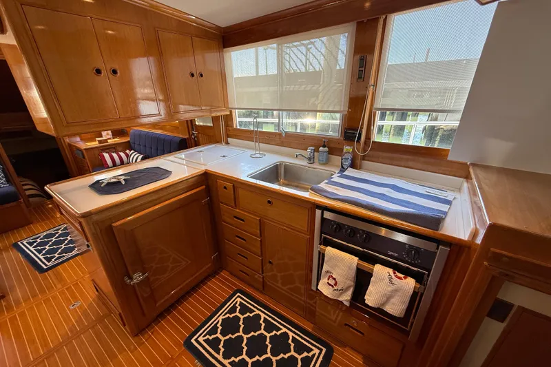 Slide: The Image of Luxurious 2002 Grand Banks 42 Classic yacht kitchen with wood cabinetry and modern appliances. - 15
