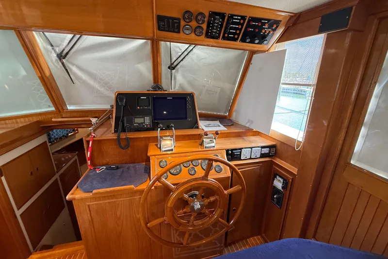Slide: The Image of Helm of 2002 Grand Banks 42 Classic yacht with wooden steering wheel and navigation equipment. - 21