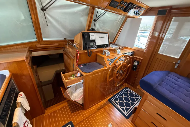 Slide: The Image of Interior of 2002 Grand Banks 42 Classic yacht with wooden helm and blue seating. - 24
