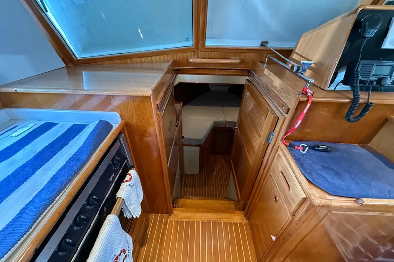 Slide: The Image of Interior of 2002 Grand Banks 42 Classic yacht with wood finish and compact kitchen area. - 25