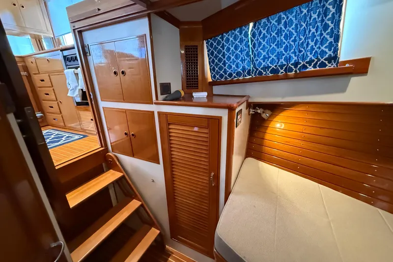 Slide: The Image of Interior of 2002 Grand Banks 42 Classic yacht with wooden cabinetry and blue curtains. - 26